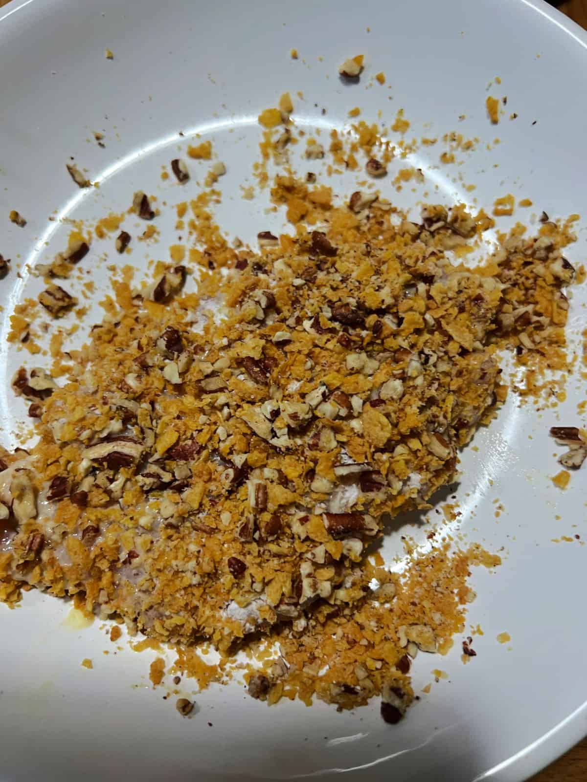 Coating chicken in pecan mix.