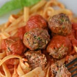 Beef and zucchini meatballs served in sauce on pasta.