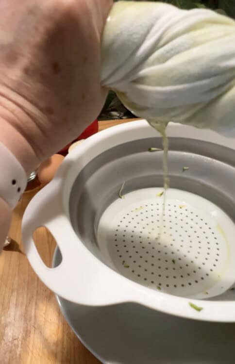 Squeezing liquid from the zucchini.