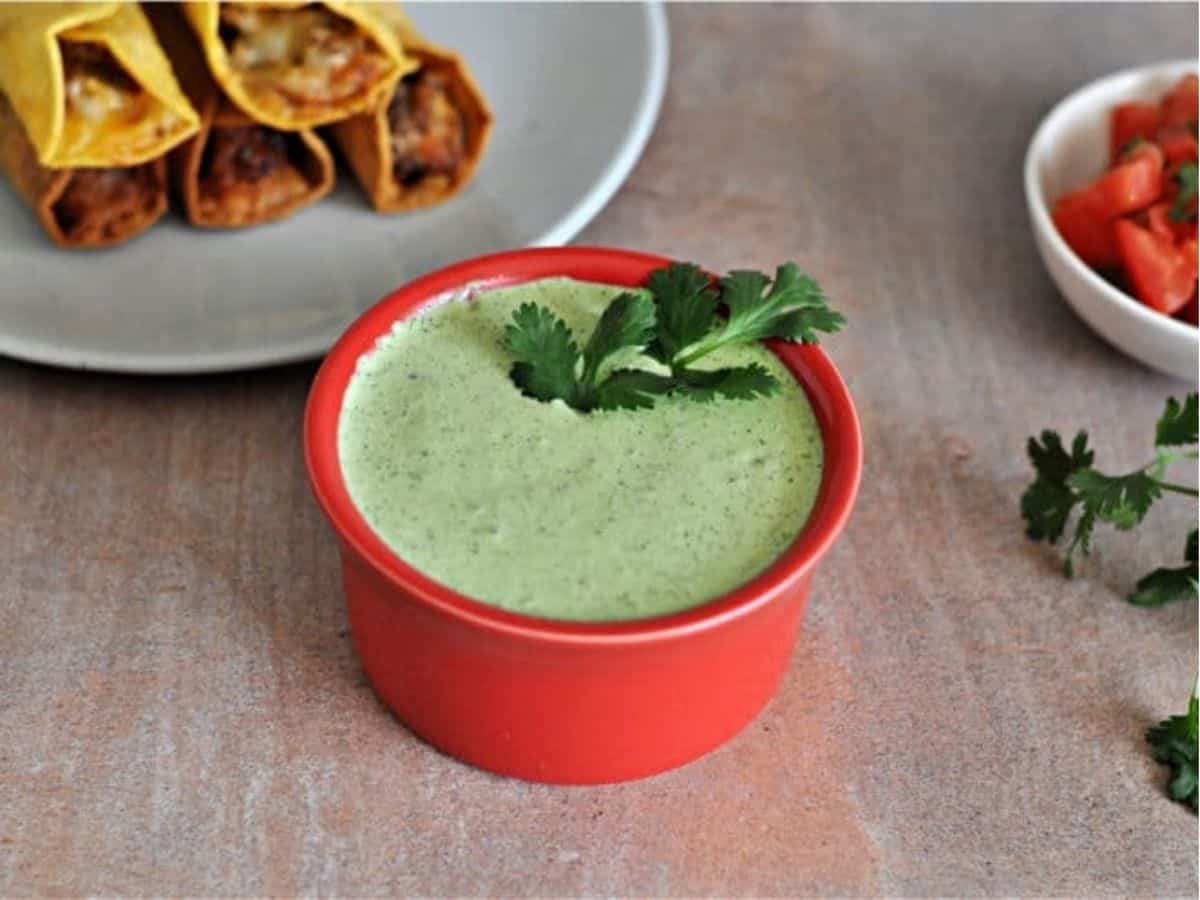 Creamy cilantro lime dressing and sauce served in a small red bowl, perfect for a taco drizzle.