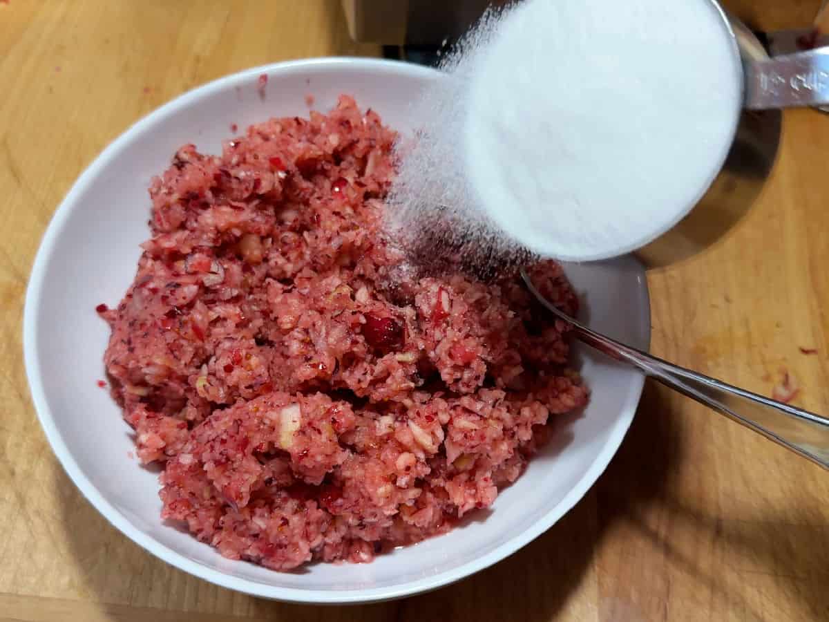adding sugar to the minced cranberry and apple.
