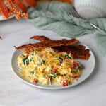 cottage cheese scrambled eggs served with bacon and ready to eat.