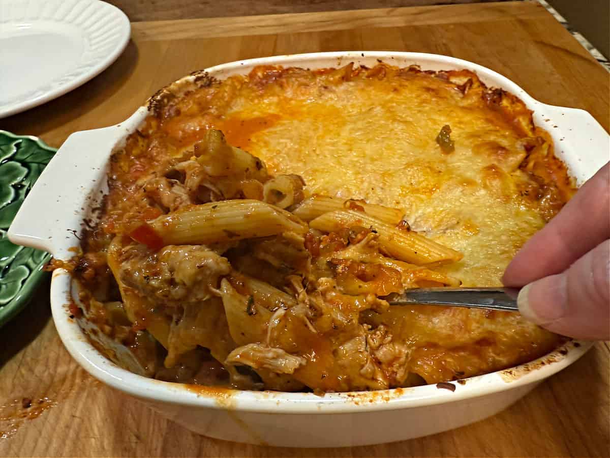 A spoonful of casserole from the baked dish, ready to add to a plate.