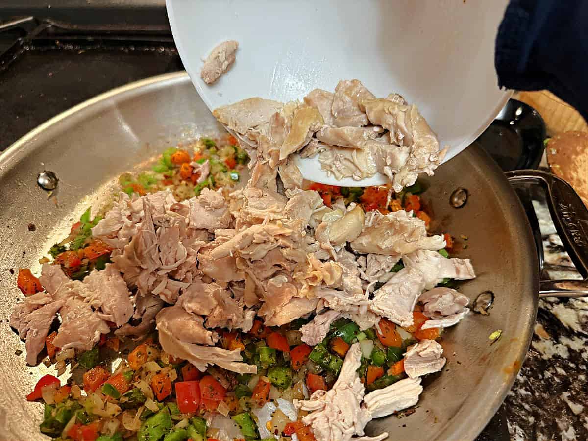 Adding cooked chicken tot he skillet to warm.