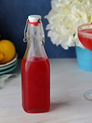 a stoppered bottle of homemade raspberry simple syrup.