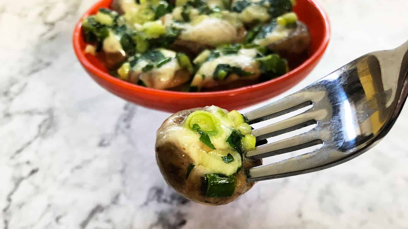 Brie stuffed mushroom on a fork.