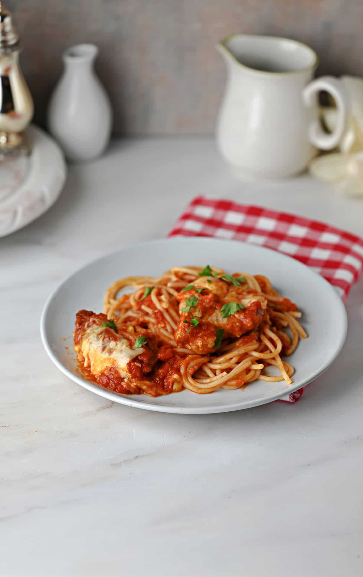Pork Parmesan and sauce served on spaghetti noodles.