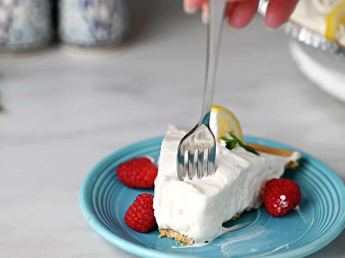 A fork getting a bite of the lemonade pie.