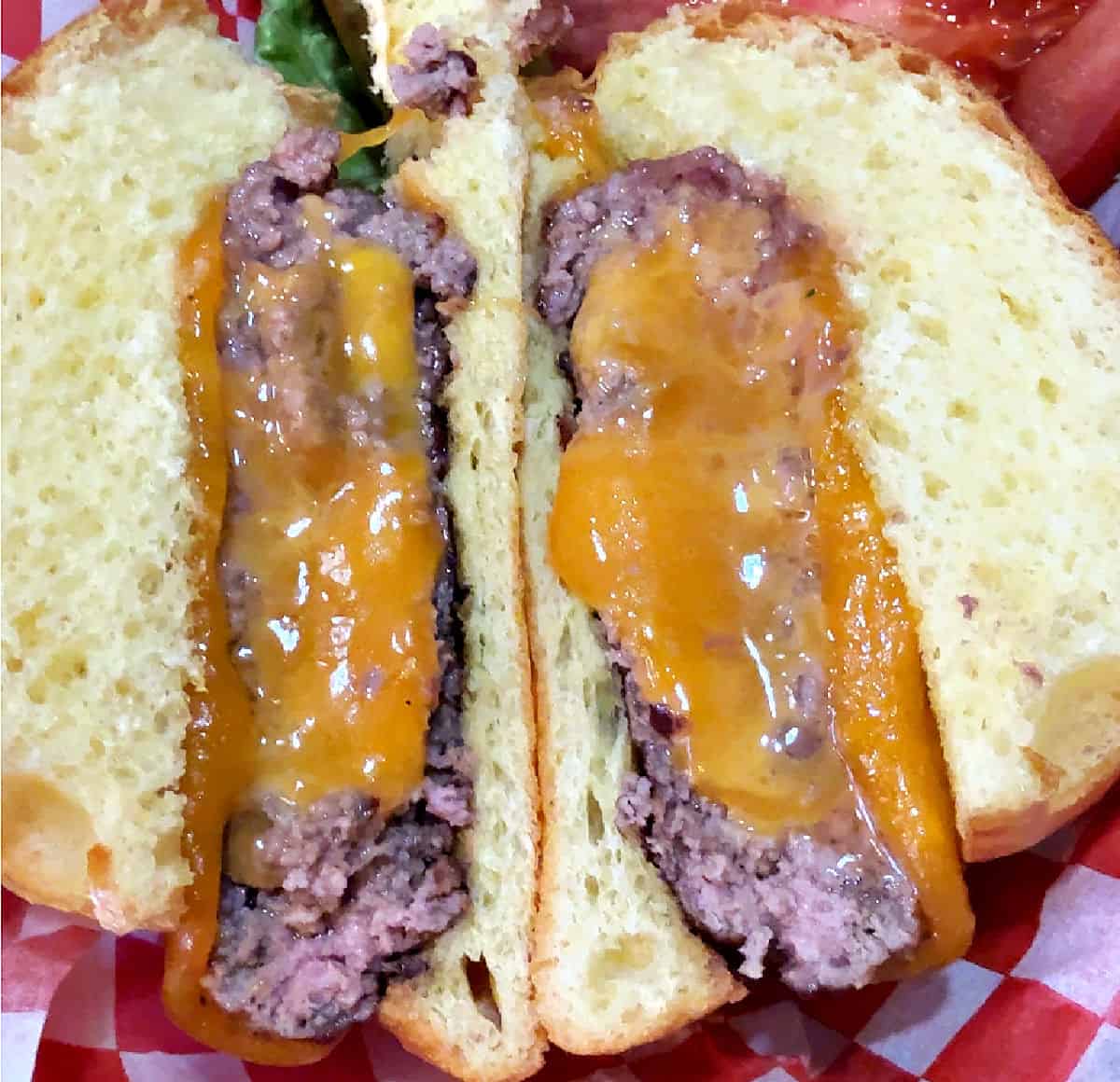 stuffed burger cut open to show the hot melted cheese.