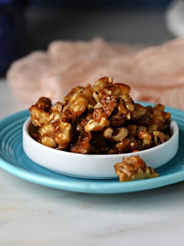 a dish of candied walnuts ready to snack on or add to a salad.