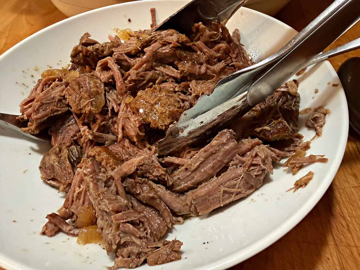 a bowl of shredded beef from the crockpot ready to use.