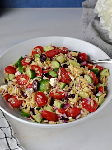 Greek orzo salad in a serving bowl, ready to eat.