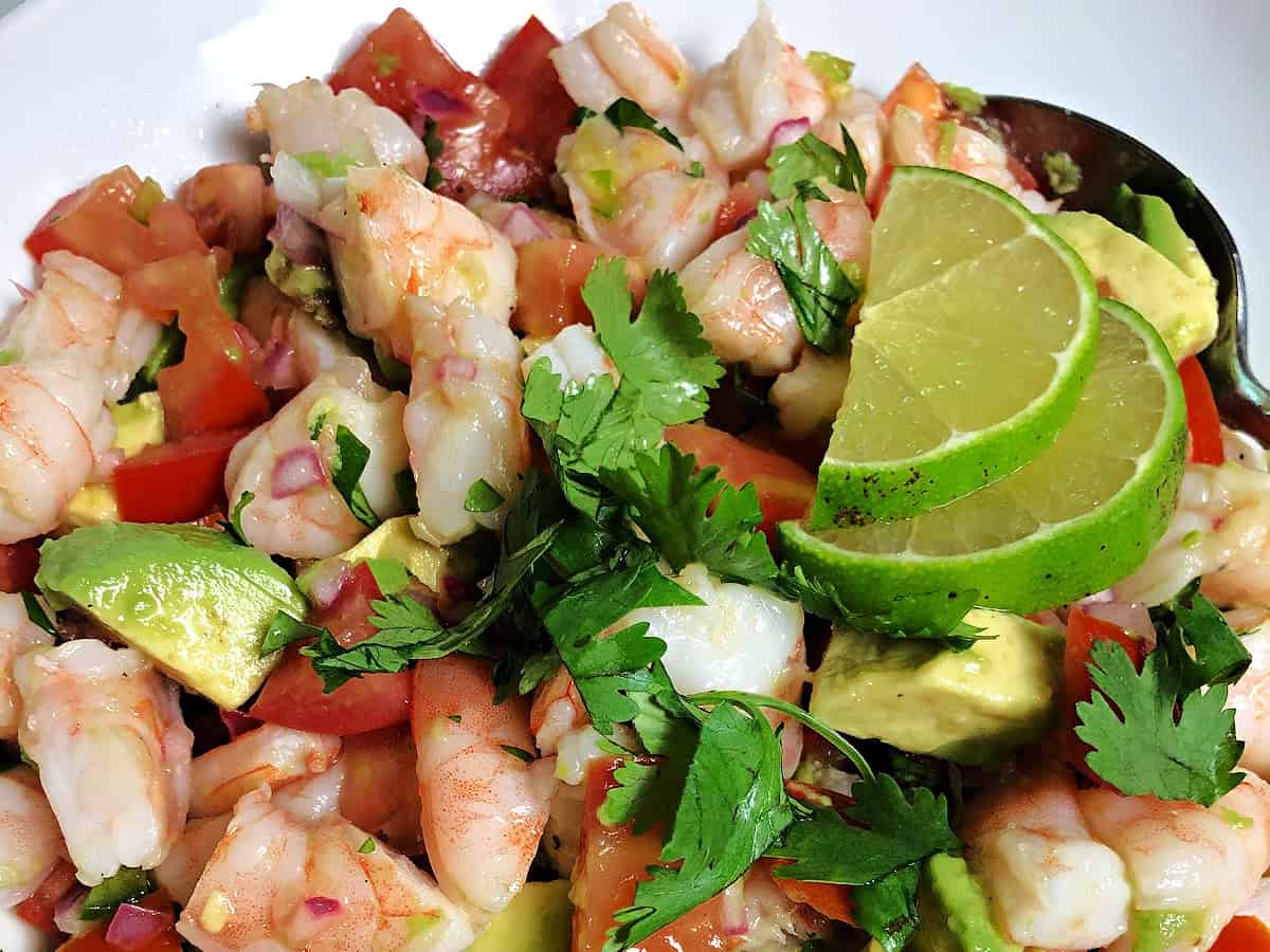 close up of shrimp and avocado salad garnished with lime slices