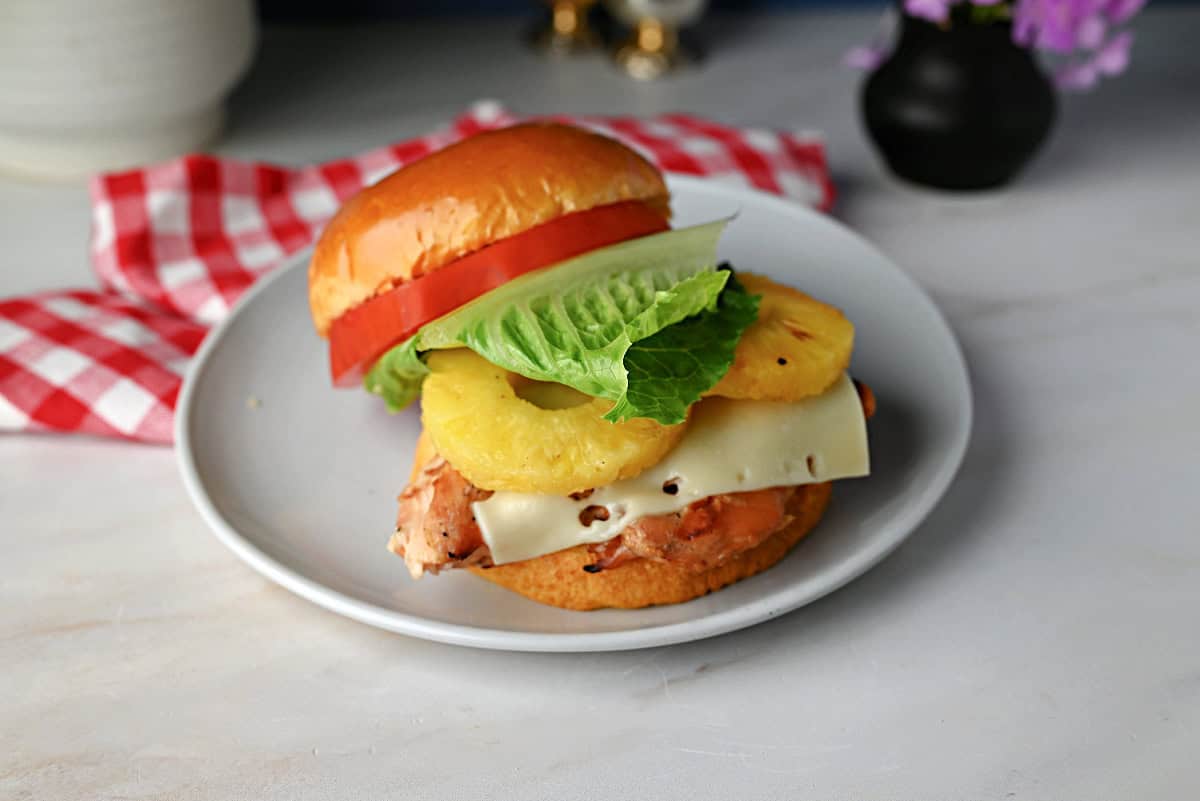 Teriyaki chicken sandwich assembled, on a plate, and ready to eat.