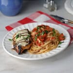 a plate of bruschetta chicken and pasta ready to eat.