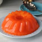 a molded orange sherbet jello salad ready to serve.